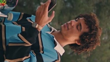 Gün batımında karşıdan karşıya geçen öğrenci. Yakın plan. Paten kayan adam cep telefonunun yanında dikey görüntü kaydediyor. Kıvırcık delikanlı Nehir Köprüsü 'nde vakit geçiriyor. Günümüz gençleri akşam yürüyüşünün tadını çıkarıyor.