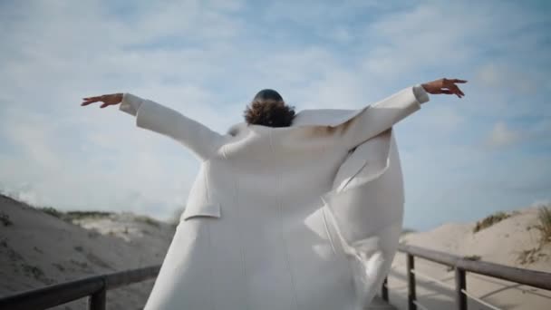 소녀는 바람이 후방보기에서 펼칩니다 부두에서 자유를 느끼는 순간을 즐기는 편안한 — 비디오