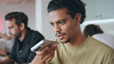 Latin adam kafeteryayı kapatıp sesli mesaj kaydediyor. Yakışıklı genç adam hoparlörde konuşuyor modern akıllı telefon barda dinleniyor. Bıyıklı serbest çalışan cep telefonu uygulaması ile sesli mesaj gönderiyor.