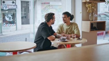 Modern kafeteryadaki romantik buluşmada flört eden iki gay. Kahvede gülümseyen ve romantizmin tadını çıkaran homoseksüel eşler. Tasasız mutlu çok ırklı aşıklar hafta sonunu birlikte geçirirler..