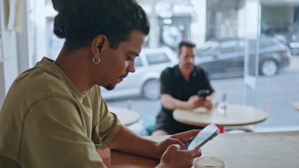 Мультирасовый Человек Пишет Смс Мобильный Телефон Сидя Кафетерии Симпатичный Латиноамериканец — стоковое видео