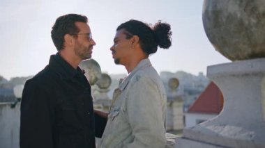 Günbatımında eşcinsel partnerler öpüşüyor. Sokakları kapatıyorlar. Çok ırklı transseksüel çifti seviyorum. Romantik bir buluşmada sevgi gösteriyorum. Mutlu homoseksüel aşıklar kaygısız şehir seyahatinin tadını çıkarırlar..