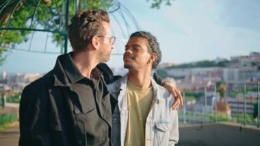 İki eşcinsel sokakta flört edip romantik bir hafta sonu geçiriyorlar. Neşeli çok kültürlü lgbtq partnerleri yaz tatilinde eğlenirken gülüyorlar. Mutlu homoseksüel aşıklar kasaba manzarası yakından görünüyor..