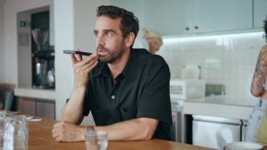 Ciddi bir iş adamı hoparlörden konuşuyor. Akıllı telefon. Sessiz kafeteryayı kapatıyor. Çekici sakallı adam cep telefonu uygulaması ile sesli mesaj kaydediyor. Tarz sahibi adam kafede sesli mesajlar yaratıyor.