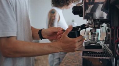 Restorandaki modern makinede kahve hazırlayan tanınmaz bir barista. Erkek elleri kafede taze aromatik sabah içeceği yapıyor. Mutfak profesyonel ekipmanında çalışan kafe çalışanları.