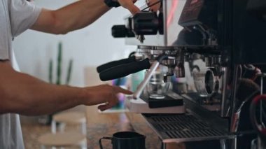 Barista elleri kafeteryada modern kahve makinesiyle kahve yapıyor. Profesyonel ekipmanlarda kafein hazırlama içeceği. Bilinmeyen kafe işçisi lezzetli espresso cappuccino yapmak için bardak koymuş.