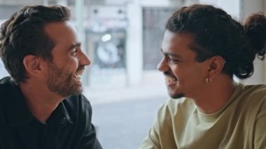 Hafta sonu tatili sırasında rahat kafeteryada öpüşen transseksüel bir çift. Neşeli, çok kültürlü iki adam öpüşerek aşklarını ifade ediyorlar. Mutlu gay Igbt partnerleri Kafe 'de romantik buluşmalar..