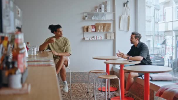 Dwóch Mężczyzn Spotyka Się Kawiarni Siedząc Osobno Przy Przytulnych Drewnianych — Wideo stockowe