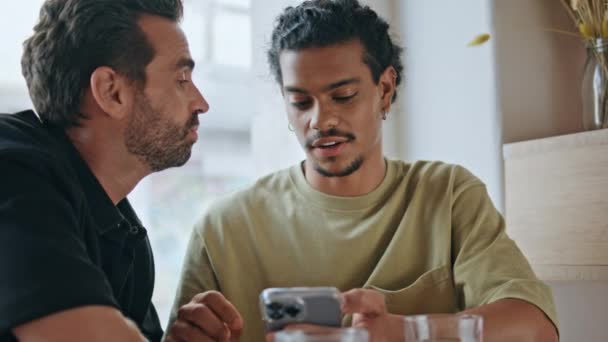 Homoseksualni Partnerzy Omawiający Wiadomości Smartfona Siedzący Blisko Małej Kawiarni Relaksująca — Wideo stockowe