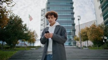 Kulaklıklı adam şehir merkezinde müzik dinliyor. Kentin arka planında cep telefonuyla mesajlaşan ciddi bir genç. Elinde akıllı telefon tutan genç adam Sonbahar Caddesi 'nde tek başına duruyor. 