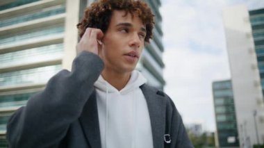 Ciddi bir genç, şehir merkezinden kulaklıkları arıyor. Genç adam şehir merkezinde telefonla konuşuyor. Moda gençliği bekleme arkadaşı şehir caddesinde duruyor. Kıvırcık öğrenci kablosuz konuşma aygıtı