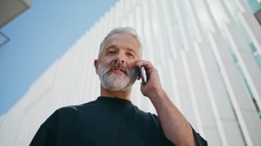 Kapalı kapılar ardında mutlu son sınıf konuşma hücreleri. Gülümseyen büyükbaba şehir binasında akıllı telefon kullanarak cep telefonu konuşmasından hoşlanıyor. Neşeli yaşlı iş adamı piercing takıyor ve aile çağrısına gülüyor..
