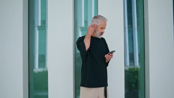 Lässiger Mann Spricht Handy Drahtlosen Kopfhörern Stilvoller Grauhaariger Geschäftsmann Telefoniert — Stockvideo