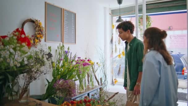 多民族夫妇一起享受花店的乐趣 两个情人在花店里卖花装饰构图 年轻的女朋友男朋友花时间在花店里 爱恋礼物的概念 — 图库视频影像
