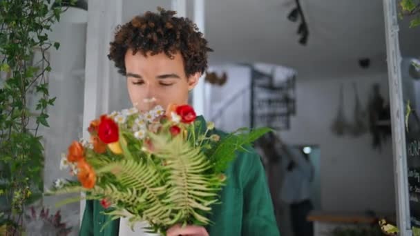 Çiçekçide Romantik Model Kamera Görüntüsü Yakışıklı Kıvırcık Adam Çiçeklerin Kokusunu — Stok video