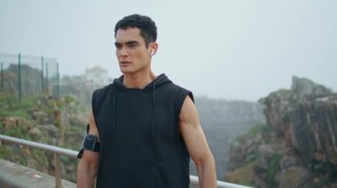 Şehir parkında spor yapan kaslı bir sporcu. Sabahları antrenmandan önce ellerini uzatan yakışıklı bir adam. Odaklanmış sporcu vücut ısıtması yapıyor. Zinde adam koşudan sonra dinleniyor..