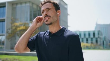 İş adamı kulaklık takıyor, Sunny Caddesi 'ni geziyor. Ciddi, zarif bir iş adamı modern kablosuz kulaklıklar kullanarak telefon görüşmesi yapıyor. Sakin patron şehir dışından arkadaşını arıyor.