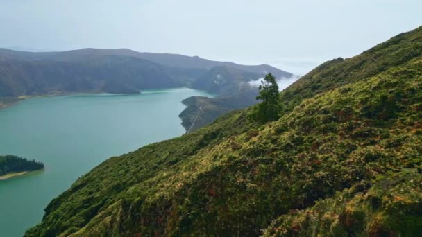화창한 아침에 파노라마 언덕을 기울기 사이에 청록색 석호의 항공기 — 비디오