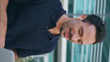 Mutlu iş adamı dikey melek kürsüsünde dizüstü bilgisayar arıyor. İnternette kablosuz kulaklık kullanarak konuşan serbest çalışan biri. Esmer adam el sallıyor vedalaşıyor sanal bilgisayar görüşmesini bitiriyor.