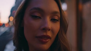 Alacakaranlık Sokağı 'nda poz veren kendine güvenen bir model. Güzel genç bir kadın gece şehir ışıkları önünde kameraya baştan çıkarıcı bir şekilde bakıyor. Muhteşem genç bayan, karanlık şehrin tadını çıkarıyor, dışarıda tek başına dinleniyor.