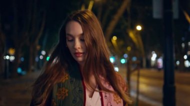 Bayan turist gece şehir ışıklarında yol trafiğine yakın bir yerde yürüyor. Çekici genç bir kadın akıllı telefon görünümlü kamerayla gece kasabasında geziniyor. Güzel, uzun saçlı bayan işten sonra aceleyle eve geliyor.