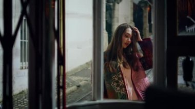 Gece geç saatlerde boş bir caddede duran kadın pencere camından kamera görüntüsüne bakıyor. Sadece şehir merkezinde poz veren kendine güvenen çekici bir model. Rahat genç kız moda ceketli rahat bir gece kasabası.