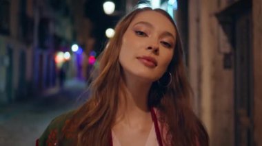 Göz kamaştırıcı kız akşam yürüyüşünden zevk alıyor. Kaygısız çekici kadın, gece şehir caddesinde geziniyor, neşe özgürlüğünü hissediyor. Mutlu bayan turist şehir sokağında sokak lambalarının altında yalnız başına dinleniyor..