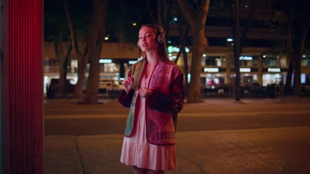 Szczęśliwa Dziewczyna Słuchawkach Stojąca Samotnie Nocnym Mieście Tańcząca Wzdłuż Ulubionej — Wideo stockowe