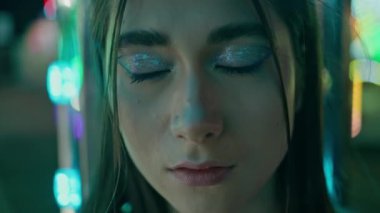 Portre neonlu kız kameraya bakıyor. Gece kulübü makyajlı çekici bir kadın. Rüya gören genç dinlenme yeri aydınlatılmış eğlence parkı. Parlak ışıklarda poz veren muhteşem bir kulüp üyesi. Güzel fütürist bayan.