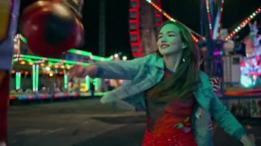 Gülen kız lunaparkta boks makinesine çarpıyor. Neşeli gençler maçta yüksek skoru kutlarken eğleniyorlar. Mutlu arkadaşlar lunaparkta eğleniyorlar. Birlikte takılıyorlar. Hafta sonu eğlence konsepti