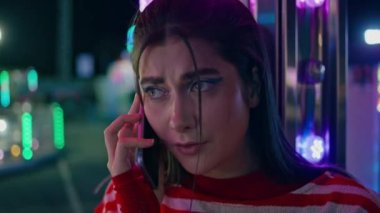 Luna Park 'taki hücrede konuşan üzgün bir kız. Endişeli genç bayan, gece festivalinde cep telefonuyla konuşan bir partneri bekliyor. Güzel, neon ışıklı bir genç. Başarısız tarih kavramı.