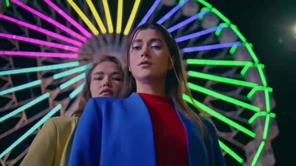 Fashion Models Looking Camera Neon Illuminated Ferris Wheel Two Girls — Stock Video