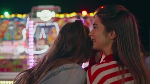 Yakından Mutlu Kızlar Lunaparkta Sırlarını Paylaşıyorlar Arkadaş Göz Kırpan Renkli — Stok video