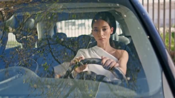 富婆摆出一副坐车的样子 自信地走近镜头 优雅时髦的女司机穿着时髦的白色西服坐在昂贵的汽车车轮上 成功的女商人享受舒适的豪华汽车 — 图库视频影像