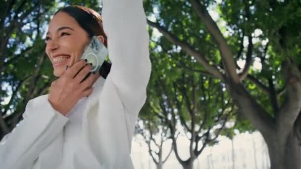 Mujer Saludando Mano Caminando Parque Ciudad Con Teléfono Inteligente Cerca — Vídeos de Stock