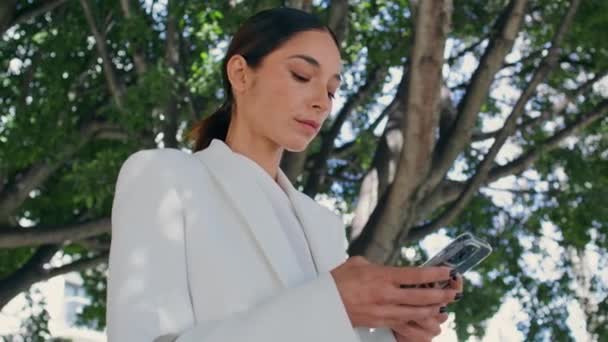 Geniş Yeşil Ağacın Altında Telefonu Daktilo Eden Meşgul Bir Kadını — Stok video