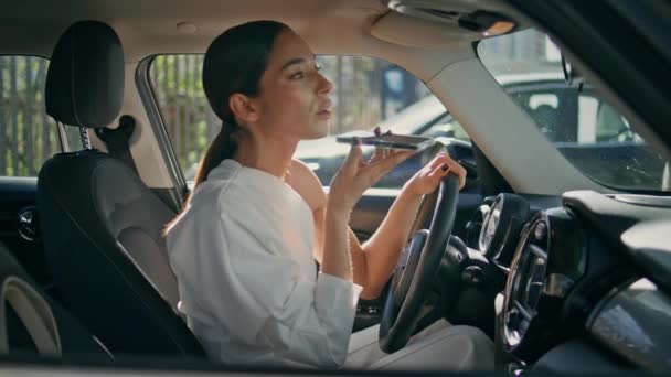 漂亮的女孩坐在昂贵的汽车旁边发送语音讯息 自信的女人在智能手机扩音器里说话 看着车镜 漂亮的女商人在汽车上使用手机 — 图库视频影像
