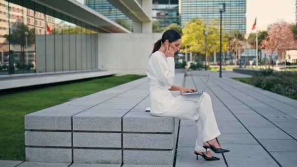 Zakenvrouw Werkt Laptop Bank Urban Straat Een Elegant Wit Pak — Stockvideo