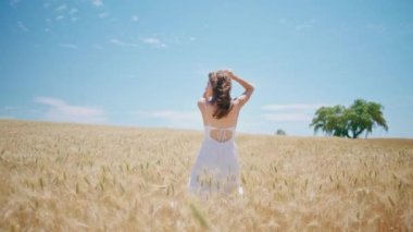 Kaygısız kadın altın mahsulleri geri görüyor. Buğday tarlasına dokunan mutlu bir kadın dinleniyor. Genç kız tek başına yaz dikenleri manzarasında geziniyor. Mevsimler kavramı