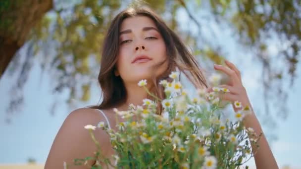 머리를 만지는 소녀는 촬영에서 자연에서 아가씨 초상화 배경에 카모마일 꽃다발을 — 비디오