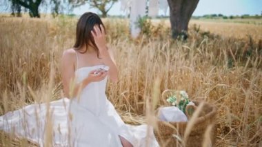 Saha pikniğinde cep telefonu mesajı okuyan genç bir kadın. Romantik hassas kız temiz havada battaniyesini örterek dinleniyor. Çavdar viskisi satan yerde oturan rahat bayan. Idyllic sahne. Yaz titreşimleri konsepti 