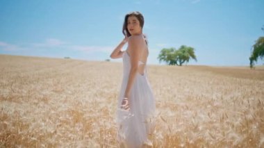 Spikelets Meadow 'un keyfini çıkaran romantik bir kız. Çavdar tarlası portresinin önünde kameraya bakan narin bir kadın görüyorum. Yazın güneş ışığında kırsal alanda poz veren bir model. Genç bayan rahatlatıcı manzara çevresi 