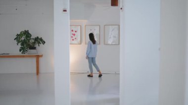 Galeri ziyaretçisi hafta sonları resimlere bakıyor. Modern sanattan hoşlanan çağdaş müzede yürüyen kadın. Tanımlanamayan düşünceli esmer teftiş koleksiyonu. İlham sergisi konsepti.