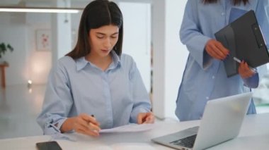 Ofiste iş sözleşmesi imzalayan bir kadın. Genç iş kadını belgeleri kontrol ederek başarılı bir anlaşma yapıyor. İş yerindeki kadın CEO 'ya yardım eden kimliği belirsiz bir asistan. Hukuki ortaklık istihdam kavramı.