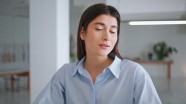 Portre tasarımcısı görünümlü kamera. Gülümseyen genç esmer ofis çalışanı. Modern stüdyoda poz veren şık küçük işletme sahibi. İş yerindeki çekici iş kadını girişimci..
