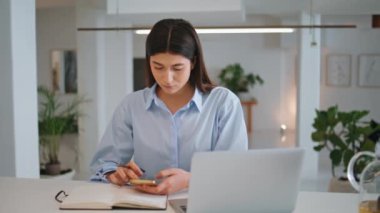 Ofiste akıllı telefonlara bakmakla meşguldüm. Teknolojik elektronik aletlerle çalışan odaklanmış kreatif yönetici. İşyerindeki konsantre kadın planlama projesi. Kurumsal insan kavramı