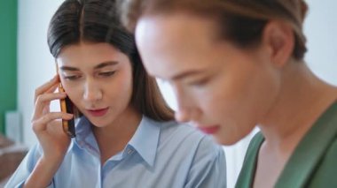 Ofis çalışanı takım toplantısında akıllı telefondan konuşuyor. Yaratıcı yöneticiler görev başında emir verme projesini planlıyorlar. Ajansta çalışan odaklanmış kadın girişimci danışman müvekkil. Sorun çözme kavramı.