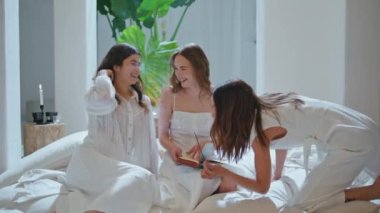 Neşeli kız kardeşler pijama partisinde evde konuşuyorlar. Mutlu kadınlar aroma çubuklarını kızlar gecesinde yakınlaştırır. Gülümseyen çekici modeller aromaterapi meditasyon uygulamalarından hoşlanırlar. Arkadaşlık eğlence eğlencesi 