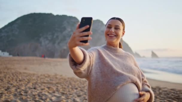Ciężarna Dziewczyna Wideo Dzwoniąc Przez Smartfona Spacery Piękne Piaszczyste Wybrzeże — Wideo stockowe