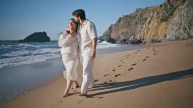 Yaz tatilinde kumlu sahilde çocuk bekleyen bir çift. Rahat romantik koca, güneşli deniz kıyısında hamile karısına sarılıyor ve okyanus dalgalarının yakınına gidiyor. Tasasız müstakbel ebeveynler hamileliğin tadını çıkarıyor.
